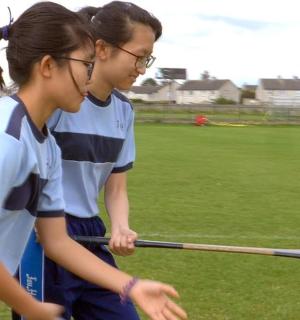Dvě dívky hrají baseball na hřišti
