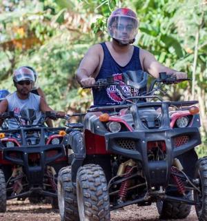 一名男子和一名男孩在小路上骑着四轮摩托车