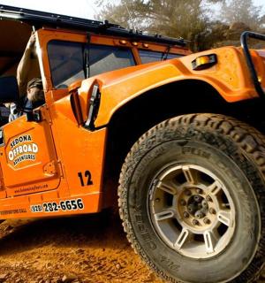 oranžový džíp zaparkovaný na prašném poli