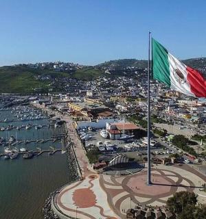 a flag flying over a harbor with boats in the water