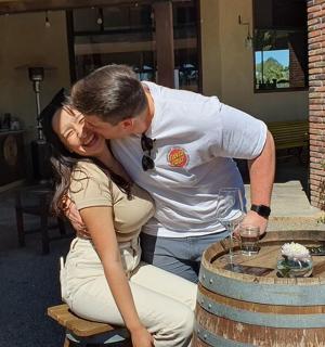 мушкарац и жена се љубе испред бурета