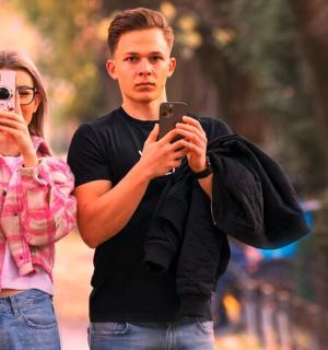 a man and a woman taking pictures with their cell phones
