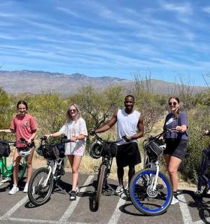 skupina lidí stojících s koly na parkovišti