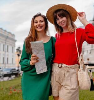 dvě ženy stojící vedle sebe před budovou