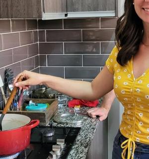 a woman standing in a kitchen stirring a pot