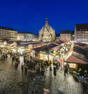 a crowd of people walking around a market at night