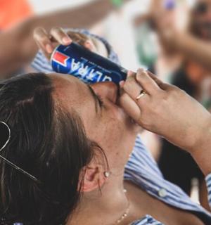 a woman is talking on a can of pepsi