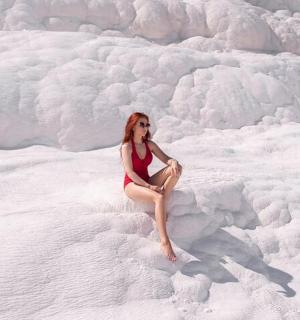 a woman in a red bikini sitting on the snow