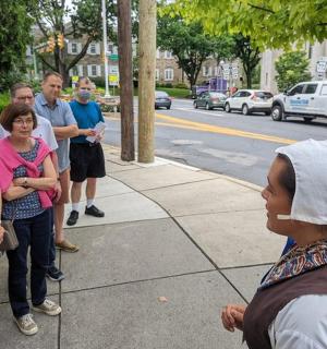 skupina lidí stojících na chodníku poblíž ulice