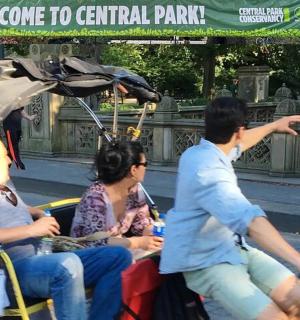 a group of people riding in a cart with an umbrella