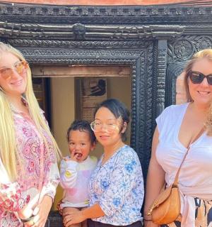 三名妇女和一名儿童站在一栋建筑物前