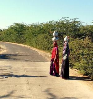 两名女子和一名骑自行车的男子站在路上