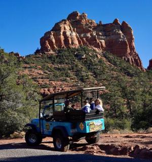 skupina lidí jedoucích v džípu na silnici