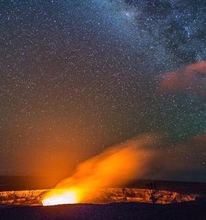 sopka v oceánu pod hvězdnou oblohou
