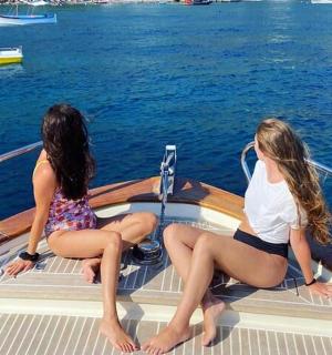 zwei Frauen sitzen auf dem Heck eines Bootes im Wasser