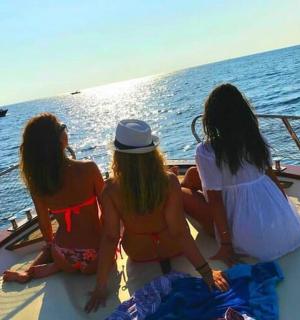 三个女孩坐在海上的船上