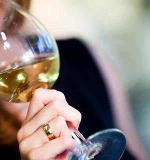 a woman drinking a glass of white wine