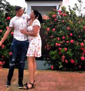 一男一女站在一丛玫瑰花前