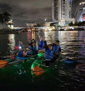 Skupina lidí v kajacích ve vodě v noci