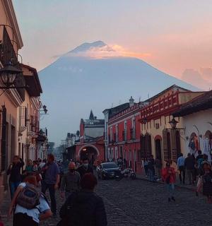 一群人走在街上，背景是一座山