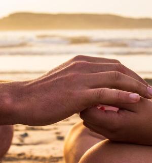 一个人坐在沙滩上，双手