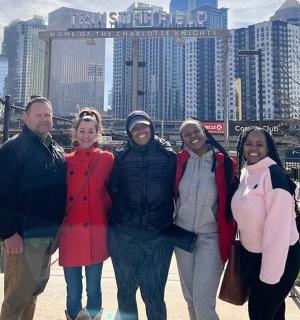 a group of people posing for a picture in front of a city