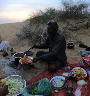一群人坐在沙滩上吃东西