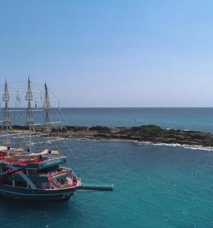two boats docked in the water next to a small island