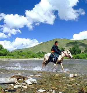 two people riding horses through a river