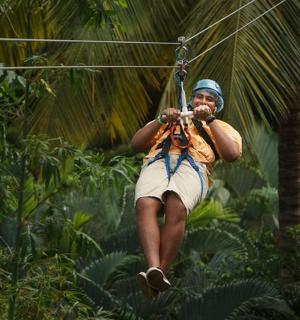 muž houpající se na zip line v džungli