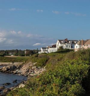 a house on a hill next to a body of water