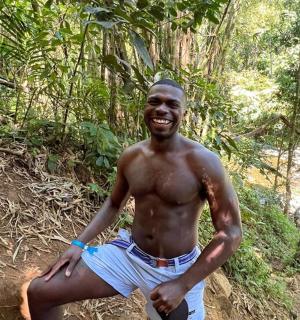 a man sitting on a rock in the jungle