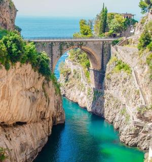 a bridge over a river between two cliffs