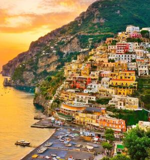 a group of buildings on a hill next to the water