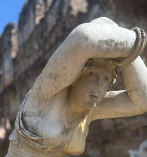 a statue of a woman holding a hat