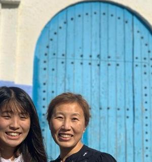 两名女子站在一扇蓝色的门前