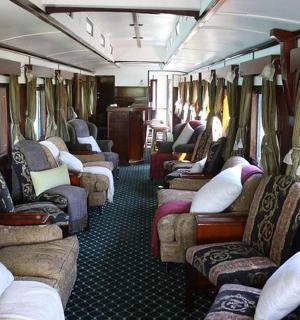 一辆有很多椅子和桌子的火车车厢