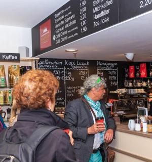 skupina lidí stojících u pultu v obchodě