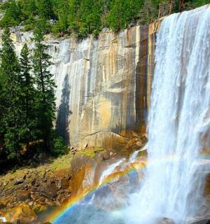 a waterfall with a rainbow on the side of a mountain