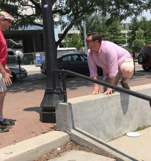 two men are looking at a man on a rail