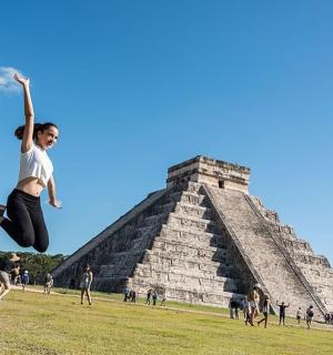 a boy jumping in the air in front of the pyramid