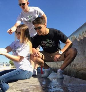 a group of people sitting on a wall near the beach
