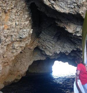 skupina lidí na lodi v jeskyni