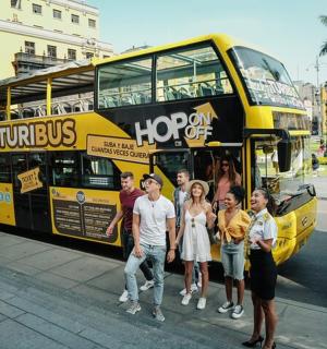 一群人站在一辆黄色双层巴士前