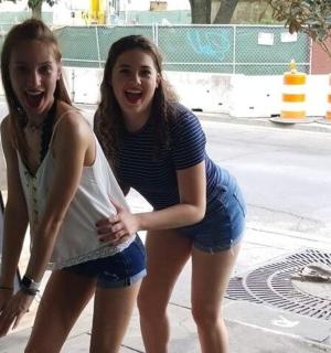 两个女孩站在一个标志旁边