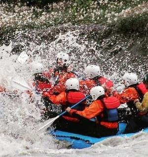 eine Gruppe von Menschen auf einem Floß in einem Fluss