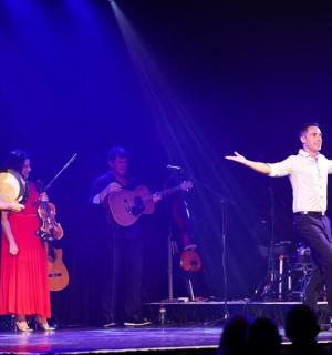 a man dancing on a stage with a group of musicians