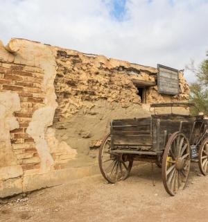 一辆木制货车停在石墙旁