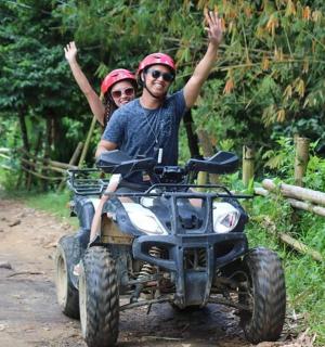 一男一女骑着四轮车在小路上行驶