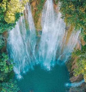 an overhead view of a waterfall in a forest